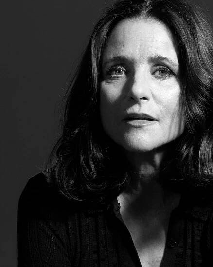 a black and white photo of a woman with shoulder length hair looking at the camera