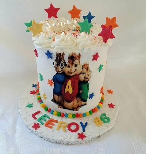 a birthday cake decorated with two chipmuns and stars