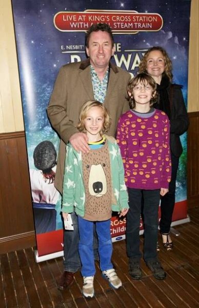 Lee Mack smiling with his wife and two sons