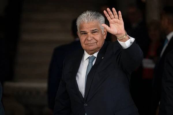 President José Raúl Mulino of Panama in a dark suit, waving with one hand.