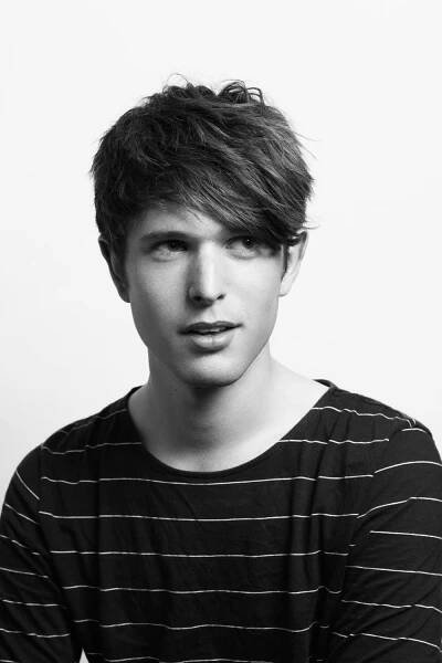 black and white photo of a young man with short hair wearing a striped t - shirt