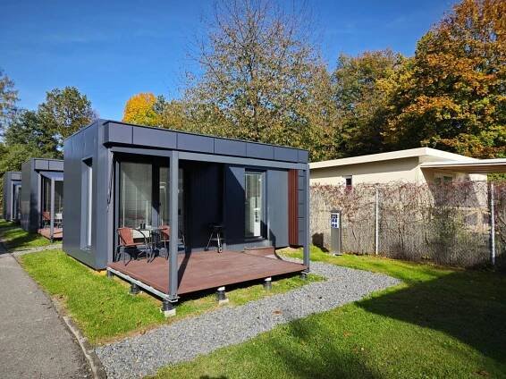 a tiny house with a deck in a yard at Apartmány Relax in Rožnov pod Radhoštěm
