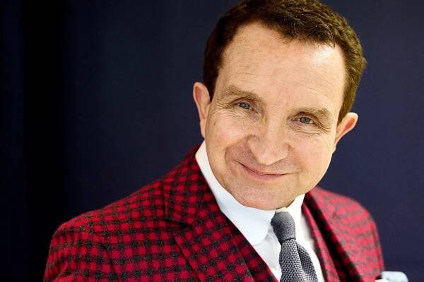 Eddie wears suit shirt, tie, and pocket square by Mark Powell.