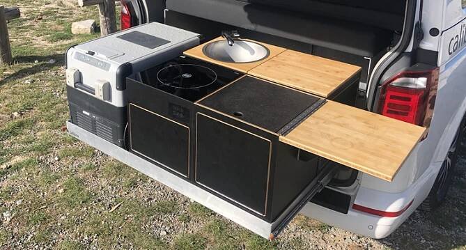 the back end of a van with an open hatchback door and wooden counter top