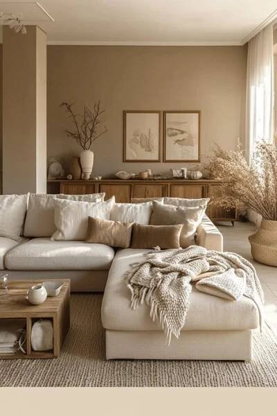 a large white couch sitting in a living room next to a wooden table and window