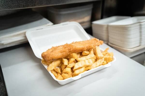 Fish and chips in a takeout container.
