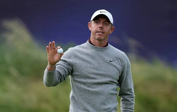 Rory McIlroy holds a golf ball.