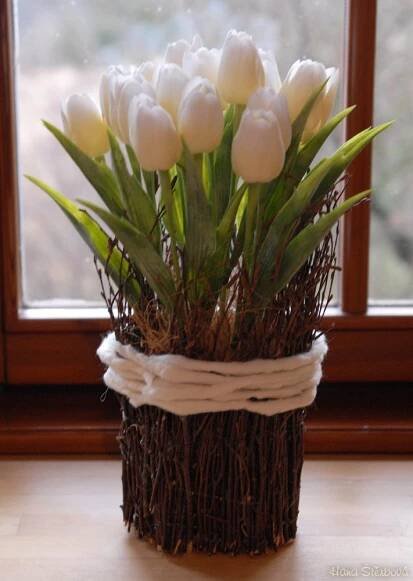 a vase filled with white flowers next to a window