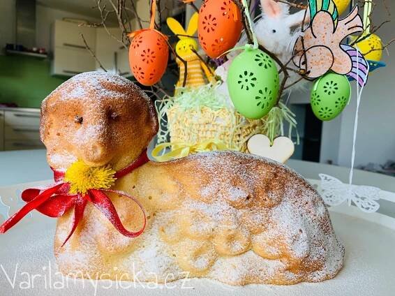 a cake shaped like a rabbit sitting on top of a table next to an easter decoration