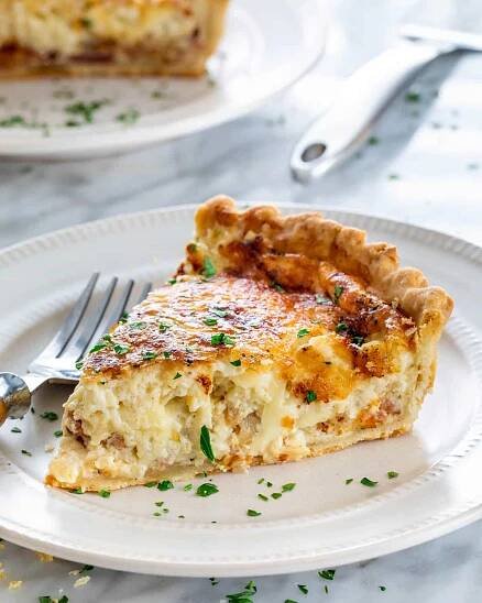 a slice of quiche on a white plate