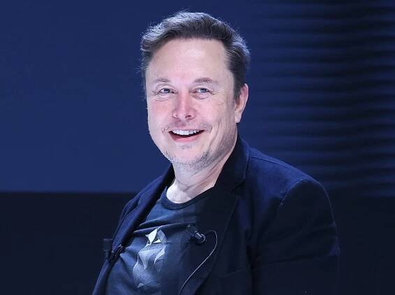 Elon Musk standing and smiling