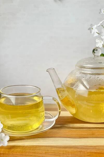 freshly steeped tea in teapot and teacup and saucer 