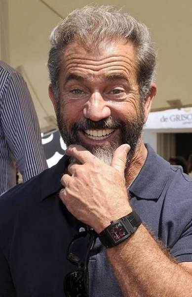 a close up of a person with a watch on his wrist and wearing a blue shirt