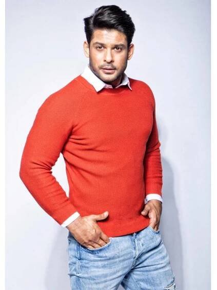 Sidharth Shukla In Red Sweater Standing Sideways Wallpaper