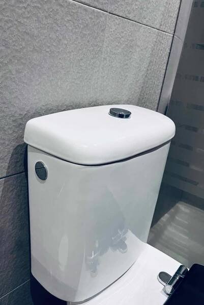 Im Test: ein Spülkasten in Weiß an einer grauen Fliesenwand über einem WC.