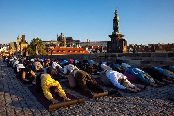 Pozdrav slunci na Karlově mostě. Čtyři stovky lidí ráno cvičily v centru Prahy jógu