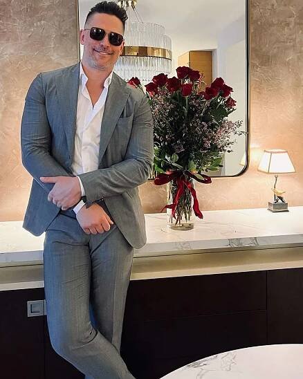 Joe Manganiello poses next to a bouquet of roses