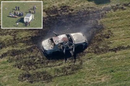 scorched car in a field after explosion