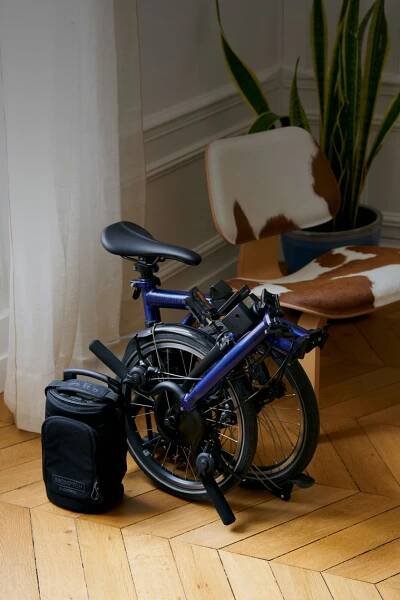 Brompton Electric C Line folded by a person working on laptop