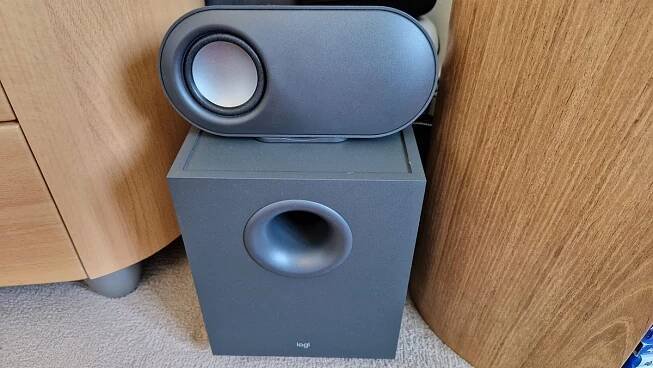 A Logitech Z407 review image showing the left hand speaker on top of the subwoofer