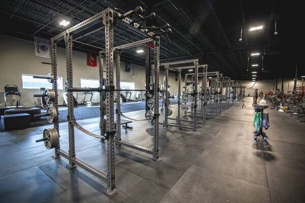 A large gym filled with lots of exercise equipment.