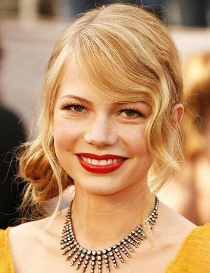 Michelle Williams wearing low bun and gem necklace on a red carpet