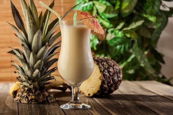 Koktejl Piña Colada namíchaný podle receptu v klasické Hurricane sklenici