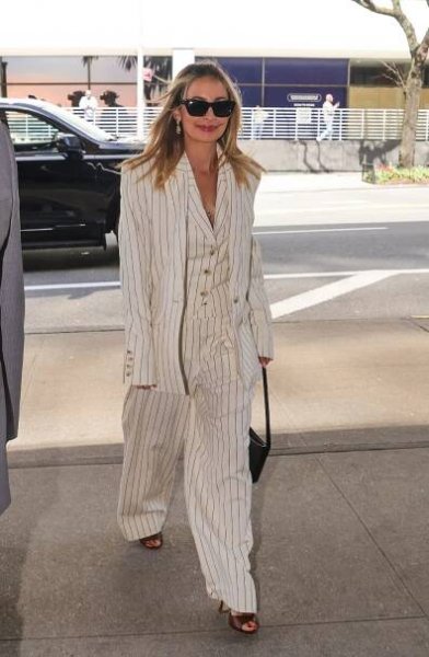 Nicole Richie wearing a white pinstripe three-piece suit with sunglasses.