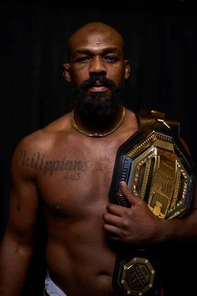 Portrait of Jon Jones holding a UFC championship belt.