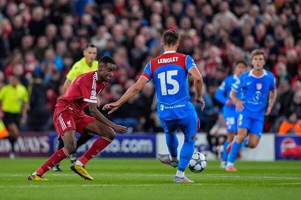 Alexander Isak of Liverpool FC and Clement Lenglet of Atletico de Madrid in action during a UEFA Champions League match.