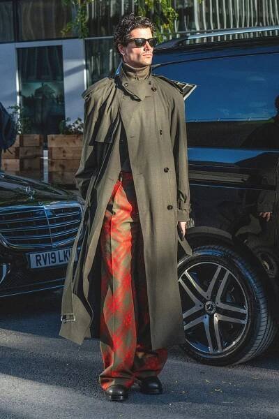 Image may contain David Chocarro Clothing Coat Accessories Glasses Adult Person Standing Footwear Shoe and Car