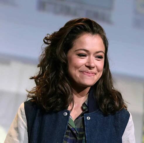 A woman in her 30s wearing authentic costumes, expressing passion for theater and geek culture.