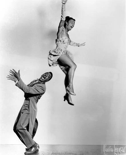 two people jumping in the air with one person upside down and another standing on his head
