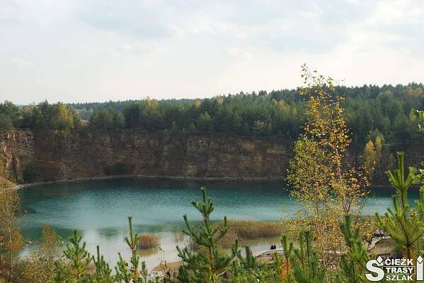 Zbiornik wodny Wydra z lazurowymi wodami otoczony wysokimi skarpami kamieniołomu w Jaworznie