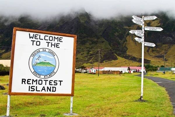 Ein Schild mit der Aufschrift "Welcome to the remotest Island" steht auf einer Wiese.