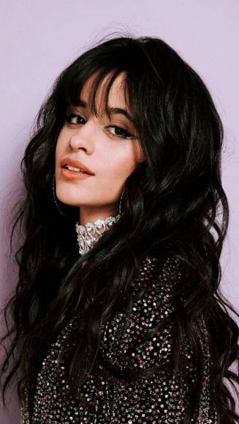 a woman with long black hair is posing for the camera