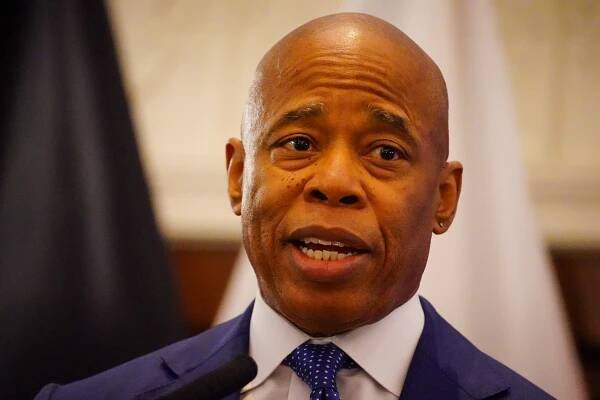 NYC Mayor Eric Adams in a suit and tie speaking at a reception at Gracie Mansion for the kickoff of Fleet week