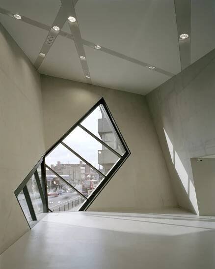 an empty room with a large window in the center and skylights on the ceiling