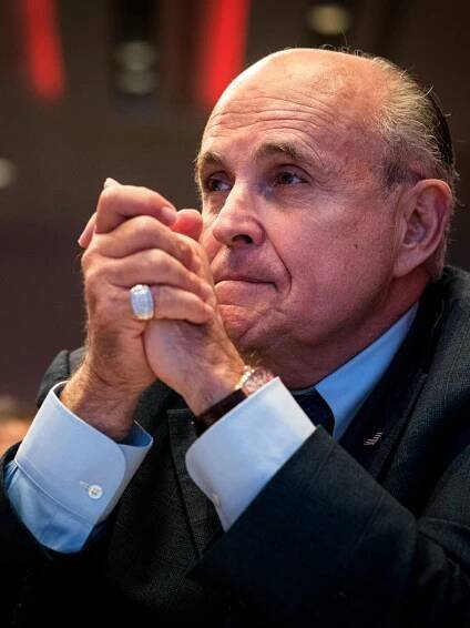 A close-up photo of Rudolph W. Giuliani holding up his clenched hands, with a serious look on his face. 