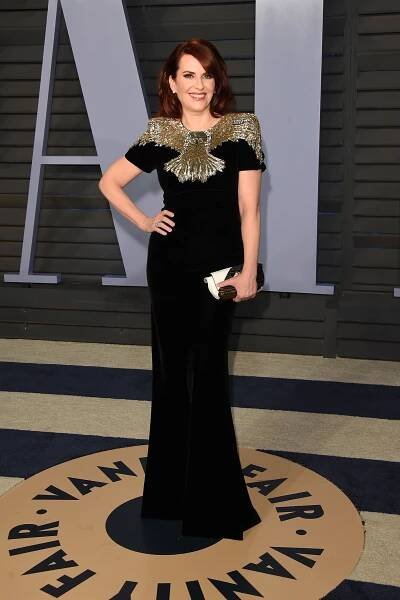 Image may contain Megan Mullally Clothing Gown Evening Dress Apparel Robe Fashion Human and Person