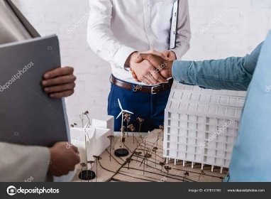 Stáhnout - Částečný pohled na afrického amerického podnikatele, jak si potřásá rukou s obchodním partnerem v blízkosti alternativního makety elektrárny, rozmazané popředí — Stock obrázek