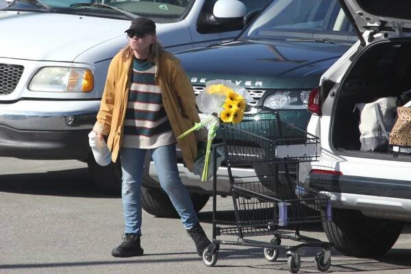 Amy Madigan grocery shopping with sunflowers.