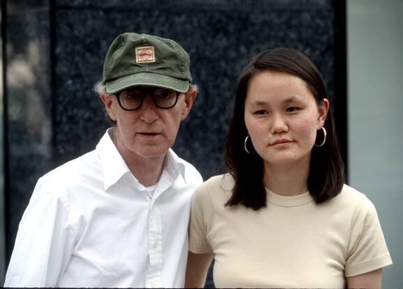 Woody Allen in a cap and glasses with Soon-Yi Previn.