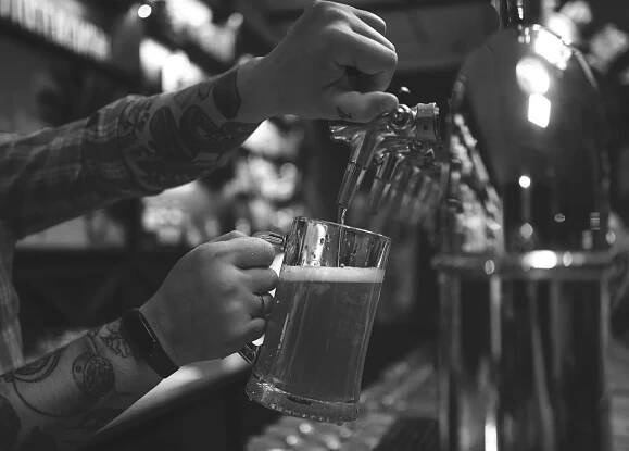 muž točící pivo na pípě