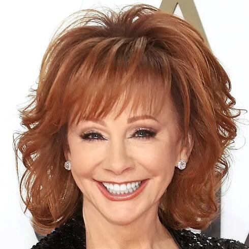 Reba McEntire smiling at camera with a shag hair cut