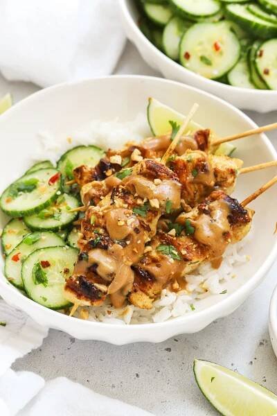 Gluten-free chicken satay skewers drizzled with homemade peanut sauce