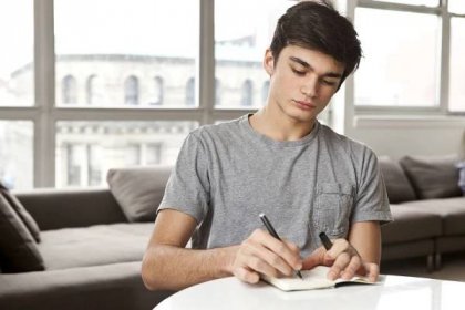 teenager at home writing notes