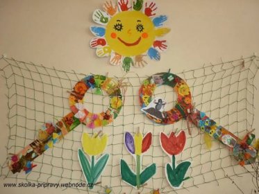 a bulletin board with flowers and handprints on the wall next to a net