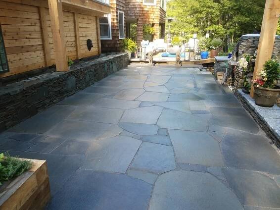 This backyard setup in Cape Elizabeth, Maine had just about everything you can throw into an outdoor living space. A large linear fishpond in the back cascades into 2 stone basins. All surrounds an impressive flagstone patio and this setup is complete with a brick oven as well. 