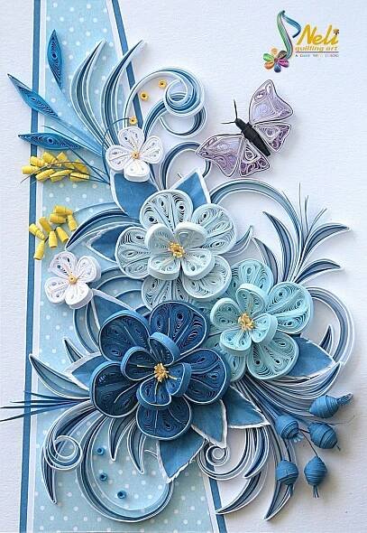 an intricate paper art piece with blue and white flowers, butterflies and polka dotes